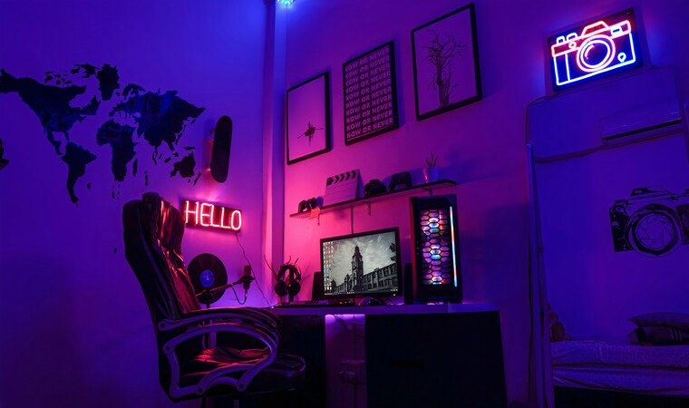 Gaming setup with neon lighting, RGB PC, and ergonomic chair.